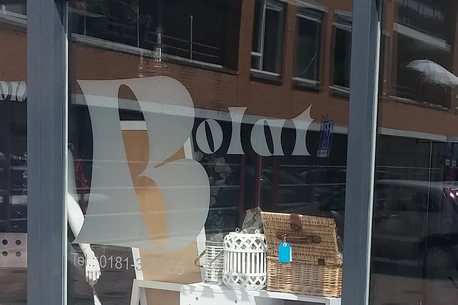 De etalage van Kapsalon Bolat met de grote witte letters Bolat op het glas